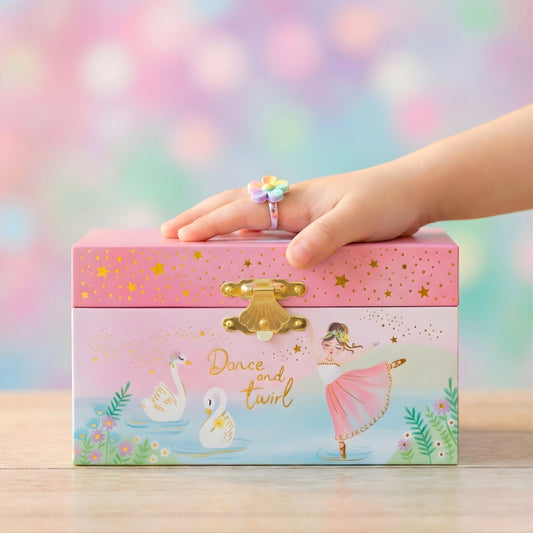 Whimsical ballerina jewelry box styled on a girl’s wooden nightstand.