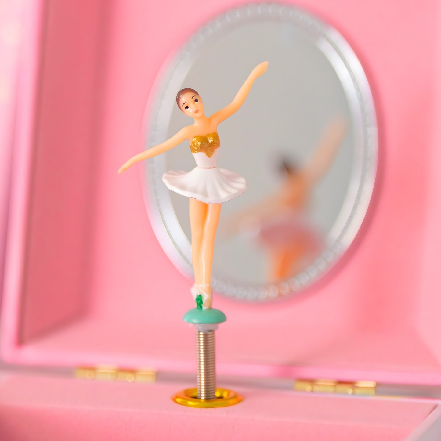 Open musical jewelry box showing a spinning ballerina figurine, interior mirror, and velvet-lined jewelry compartment.