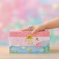 Pink jewelry box with fairy design on a colorful blurred background