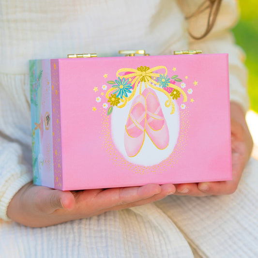 Pink box with ballet slipper design held by a person wearing a white sweater.