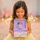 Young girl holding a purple music box with a unicorn design, surrounded by blurred lights.