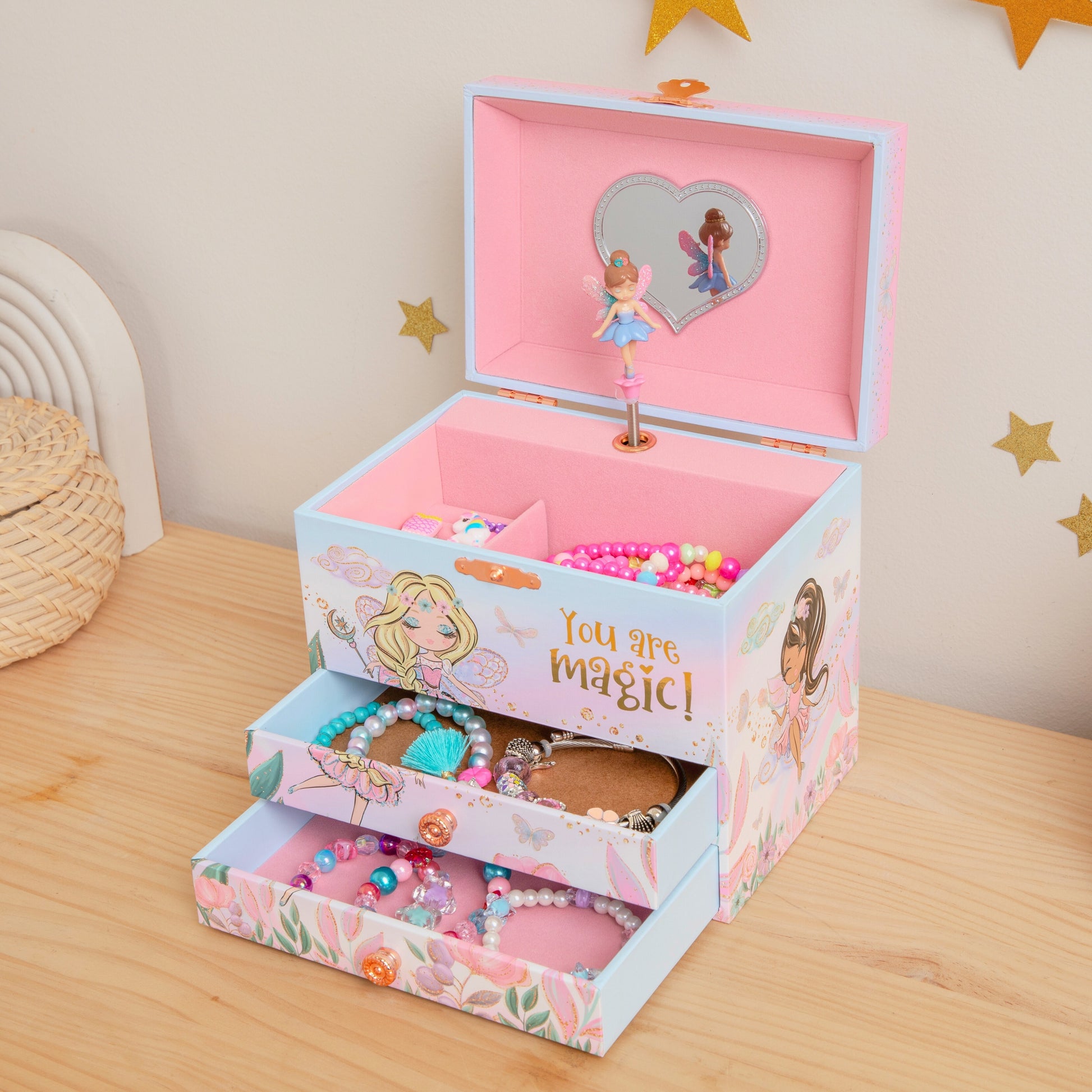 Children's jewelry box with fairy design on a wooden surface