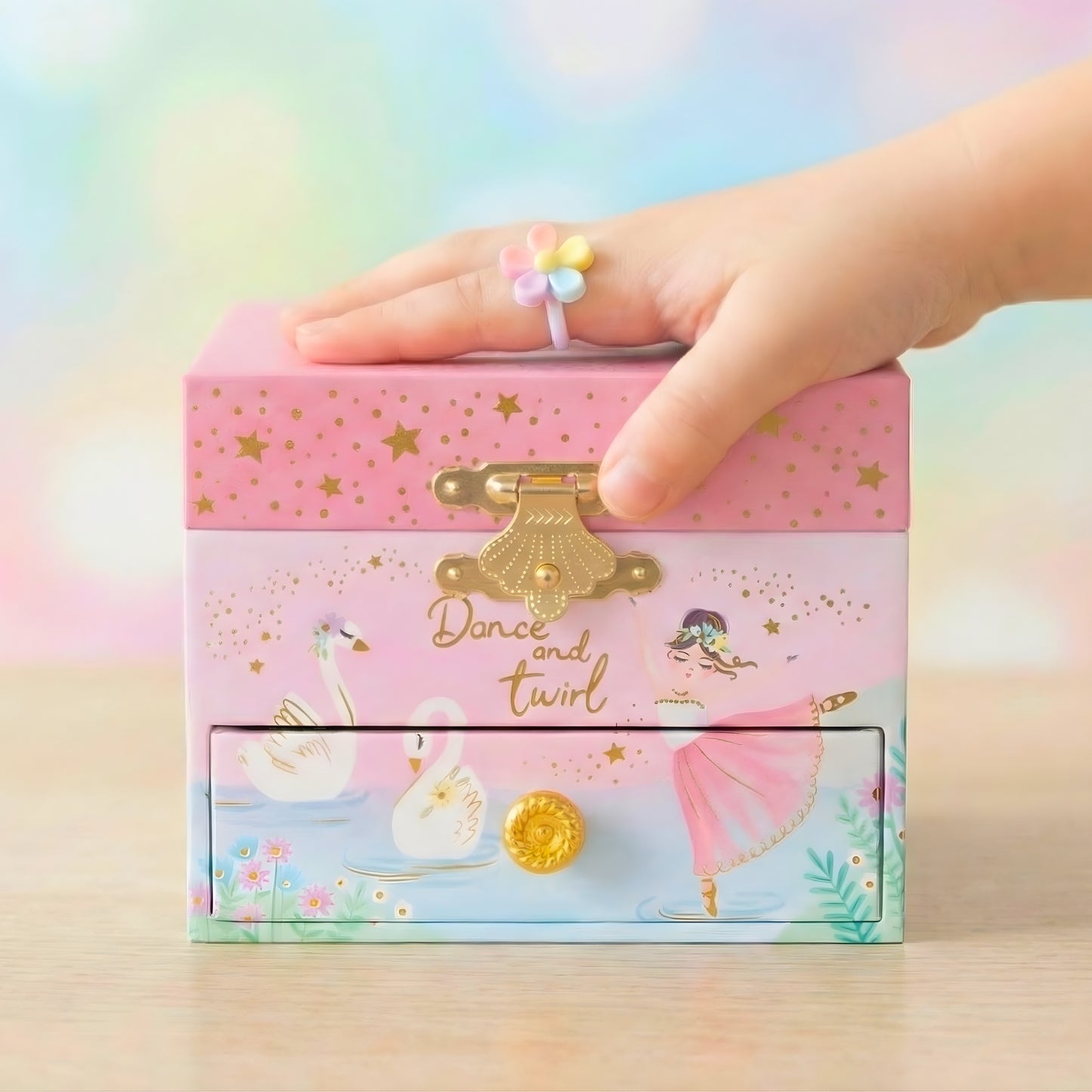 Children's jewelry box with a hand opening it, featuring ballet-themed design and 'Dance and twirl' text.